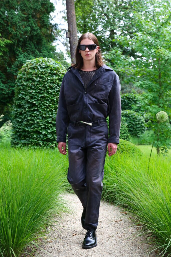 A fitted black leather jacket with long sleeves and a collared design paired with matching pants.