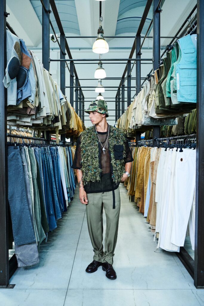 A relaxed fit green cotton sleeveless vest paired with beige pants, featuring a layered design.