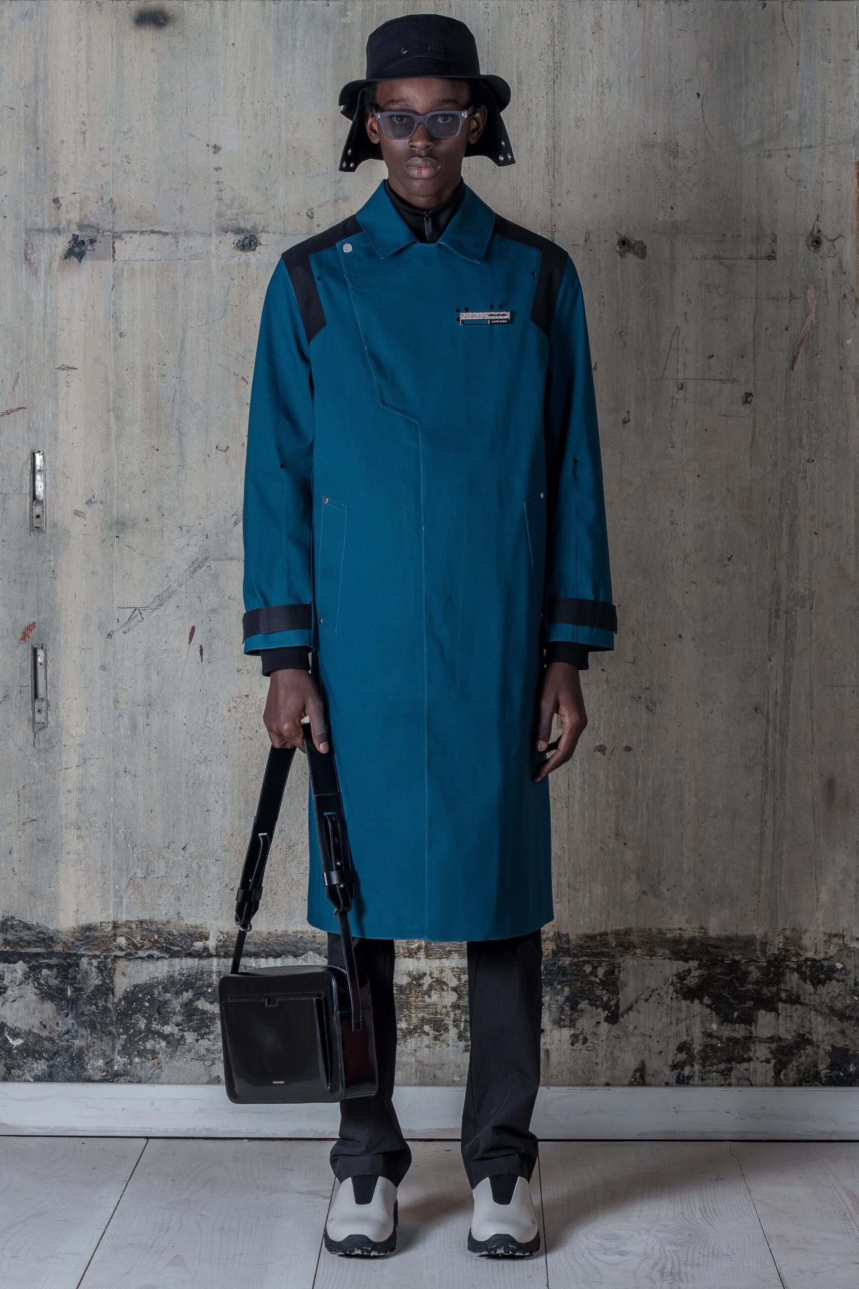A relaxed blue cotton coat with long sleeves and an asymmetric design.