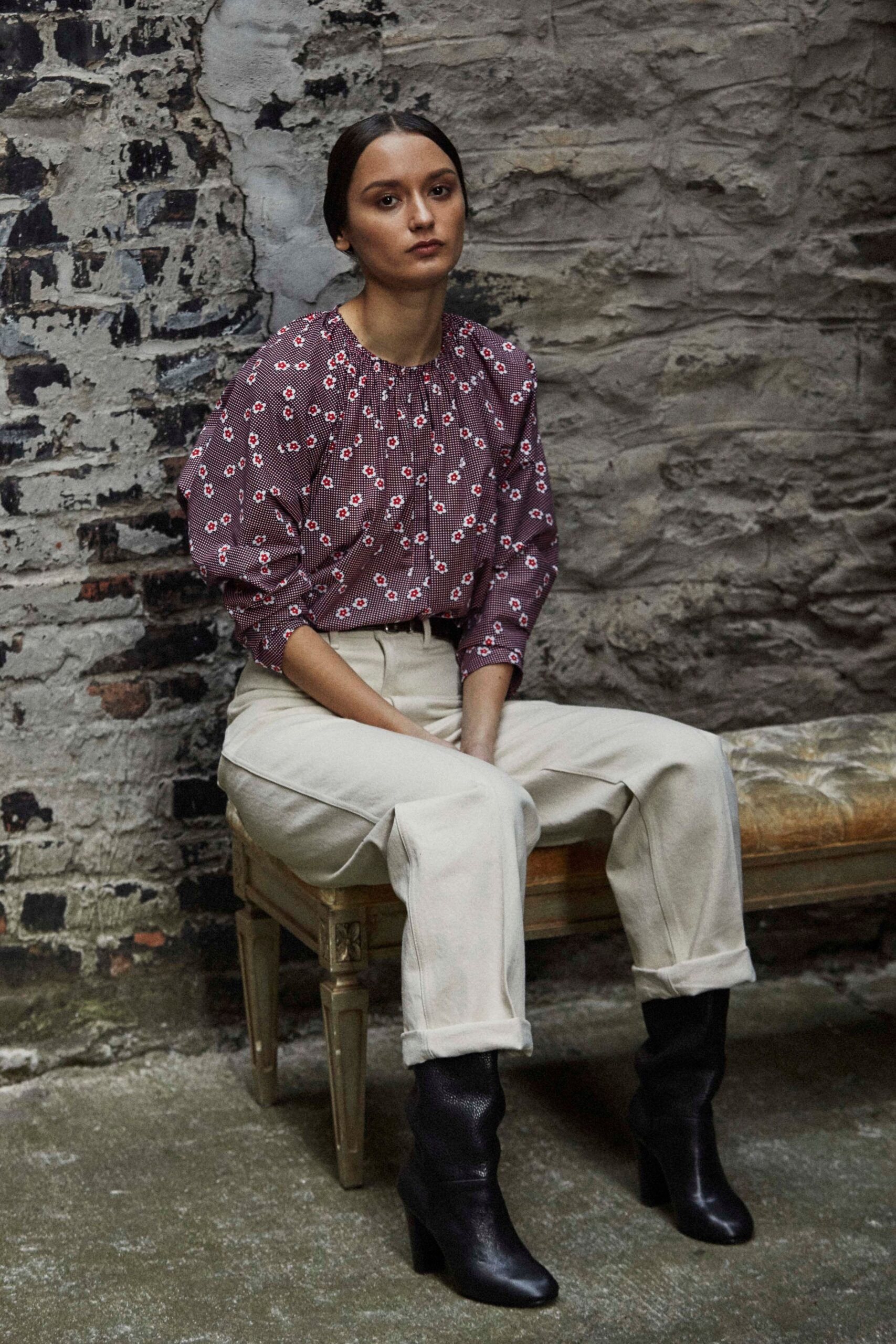 purple ruffled blouse with beige pants