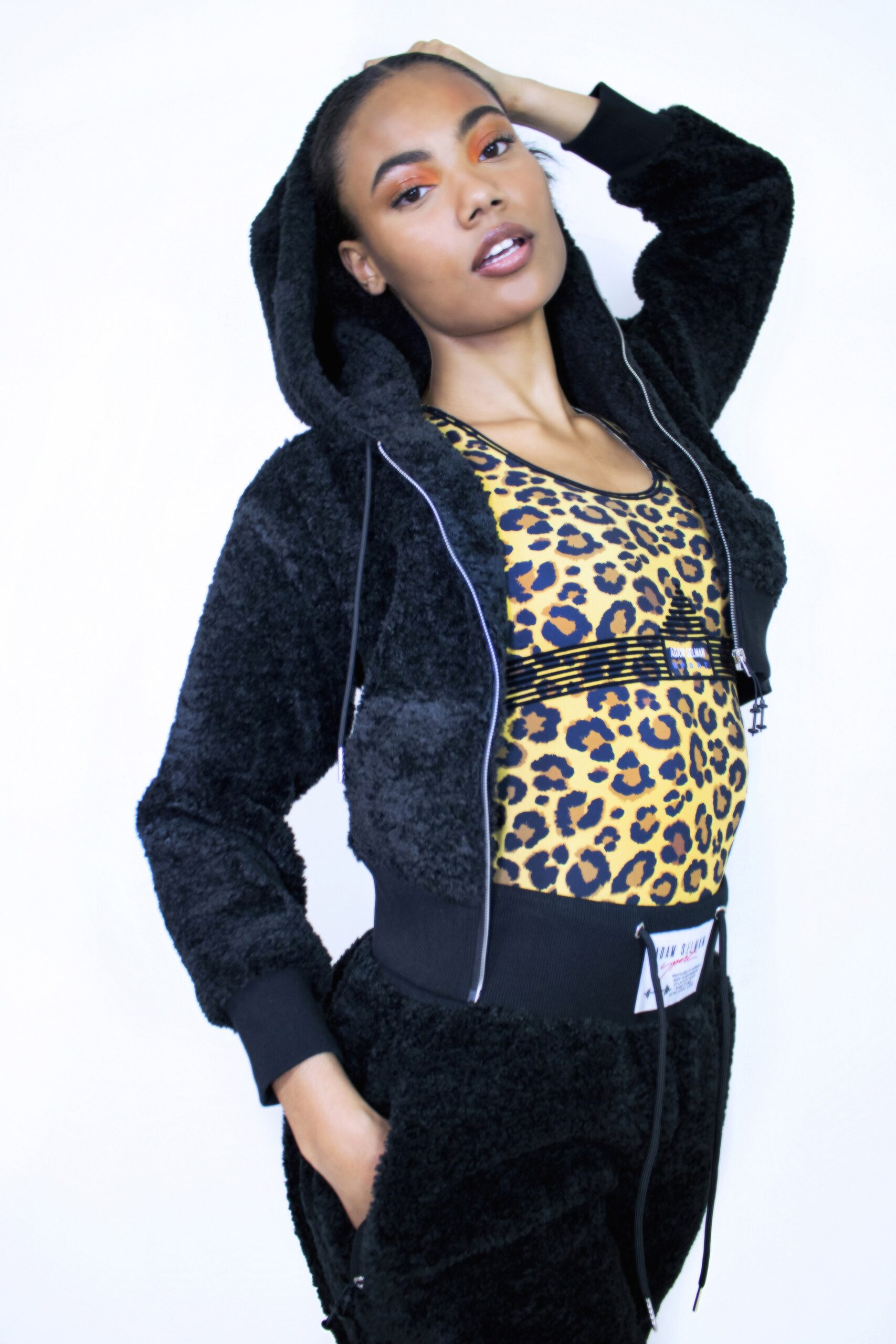 black faux-fur jacket and yellow animal-print bodysuit