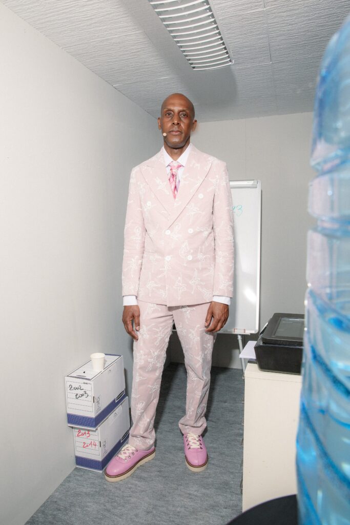 A tailored pink suit with long sleeves and a collared shirt featuring a printed design.