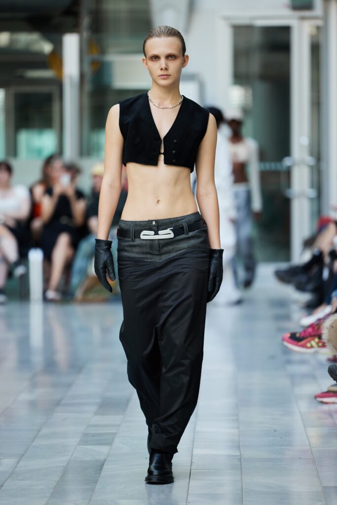 A black cropped top paired with high-waisted black pants, creating a sleek and modern silhouette.