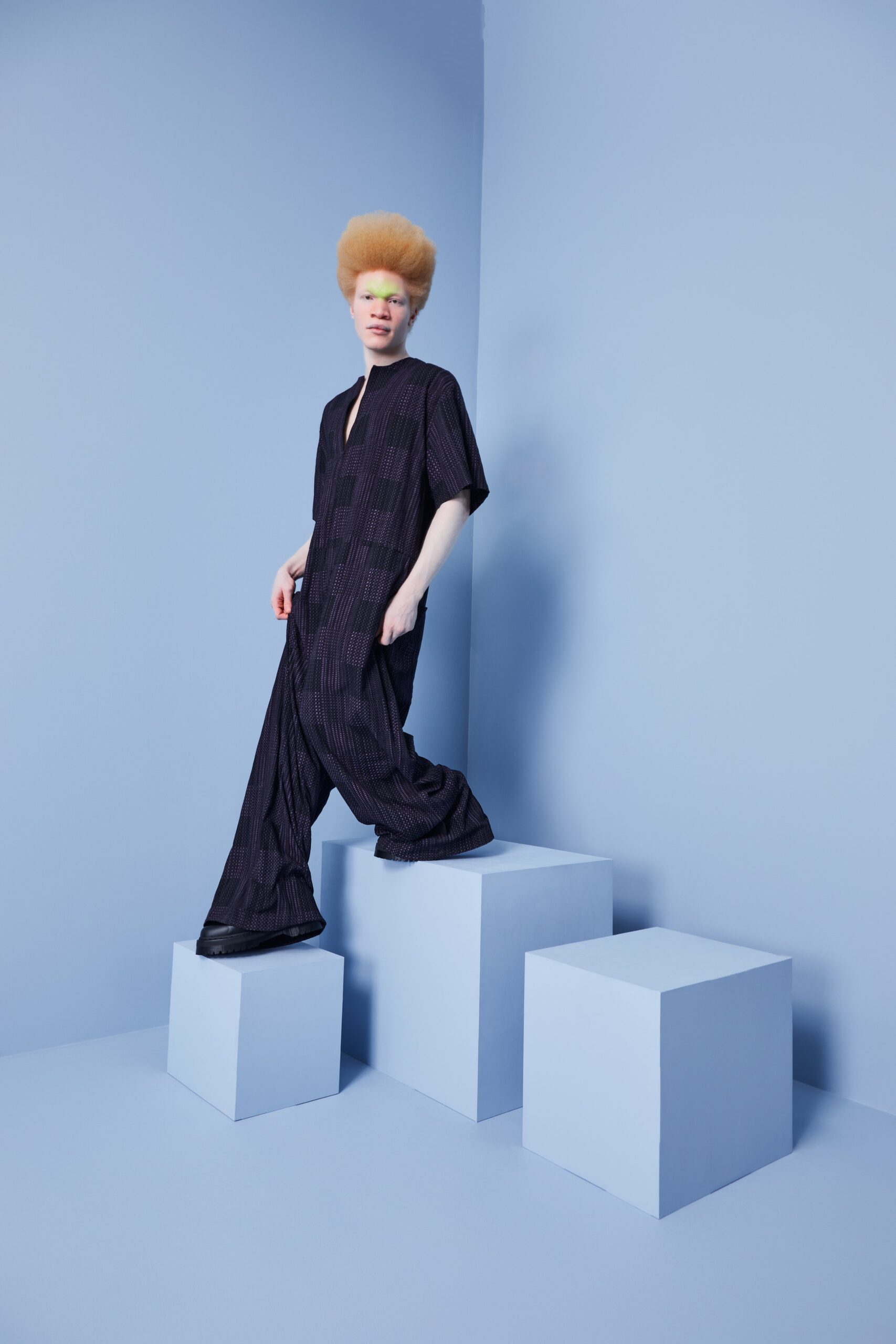 This relaxed jumpsuit features a striking wide-leg silhouette that flows effortlessly, complemented by a deep V-neckline. The subtle texture adds depth, while the short sleeves enhance its laid-back appeal, creating a modern yet versatile piece.