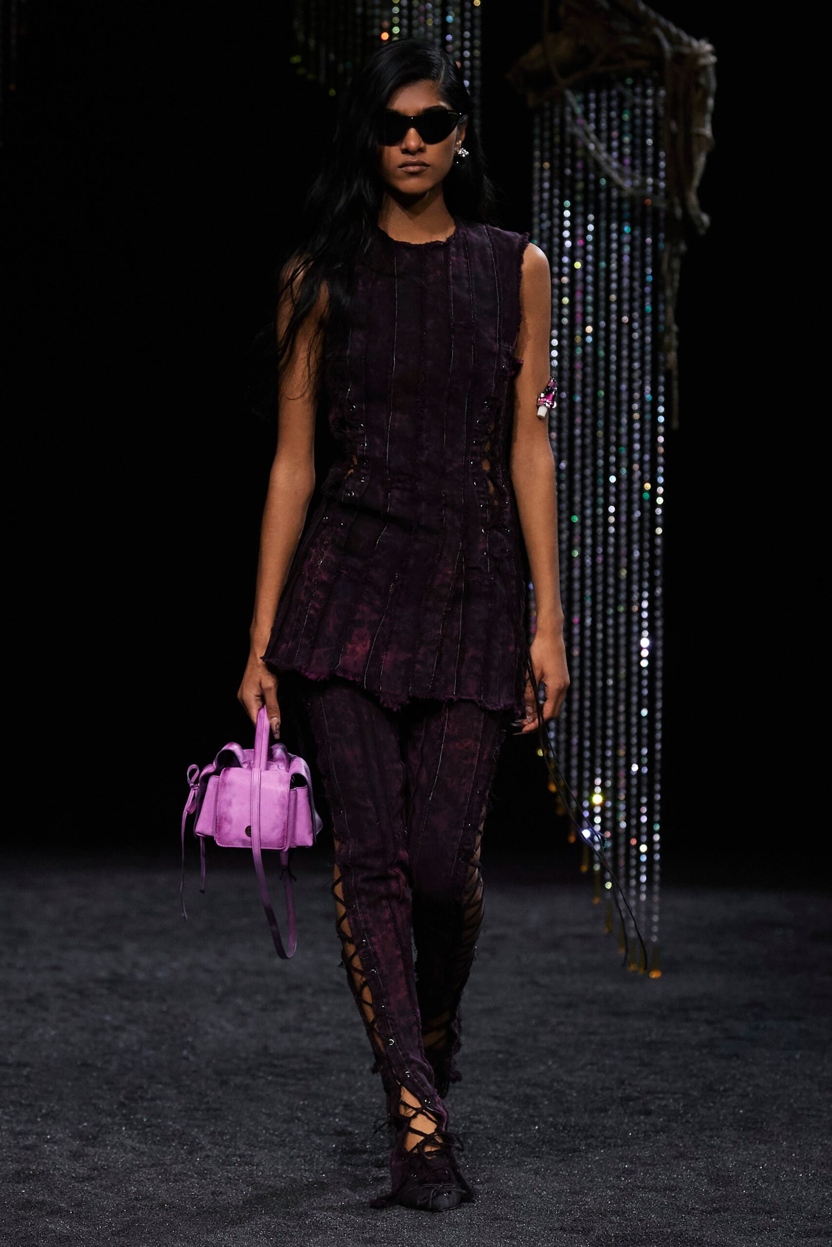A fitted purple sleeveless top with an asymmetric design paired with matching fitted pants.