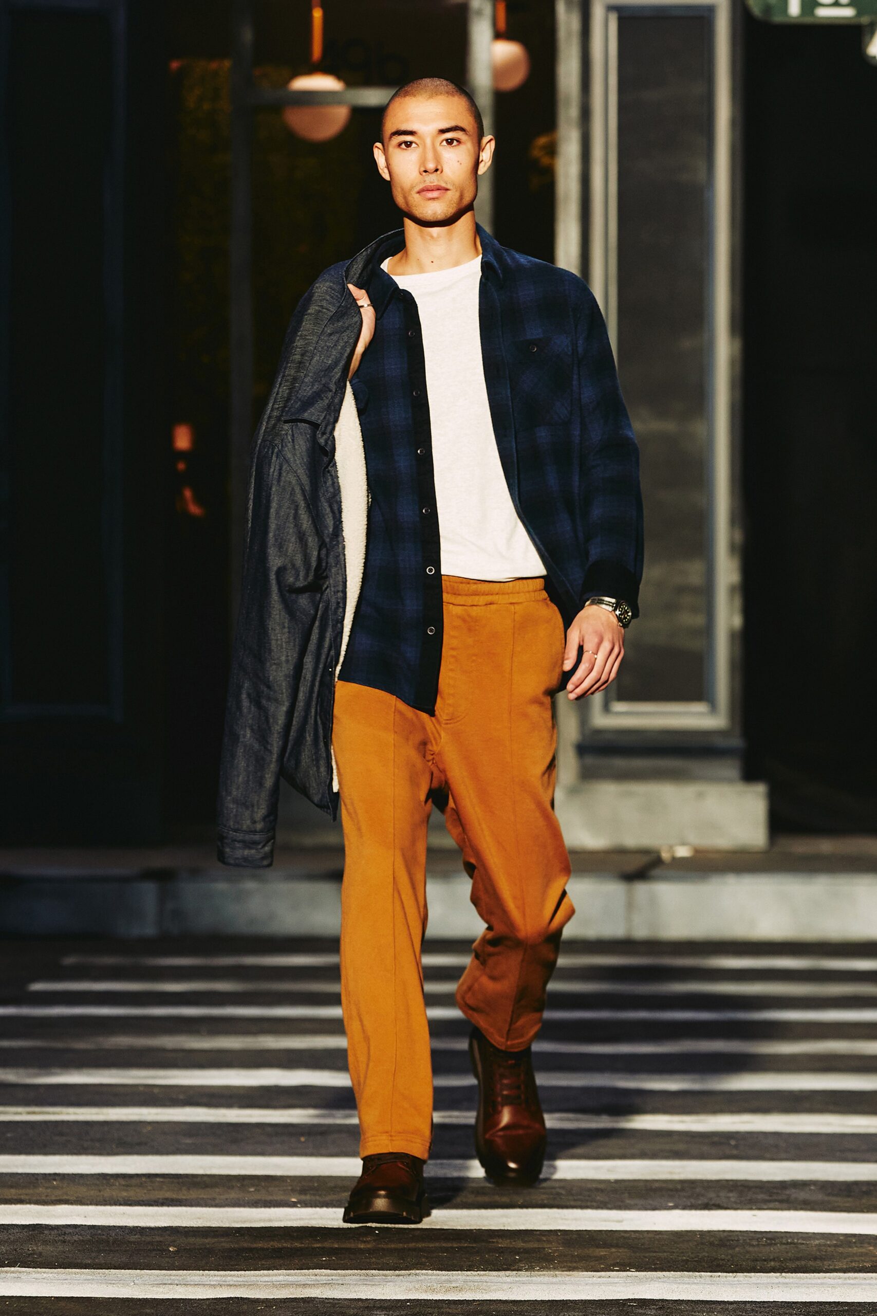 A relaxed white long-sleeve collared shirt paired with straight-leg orange pants.