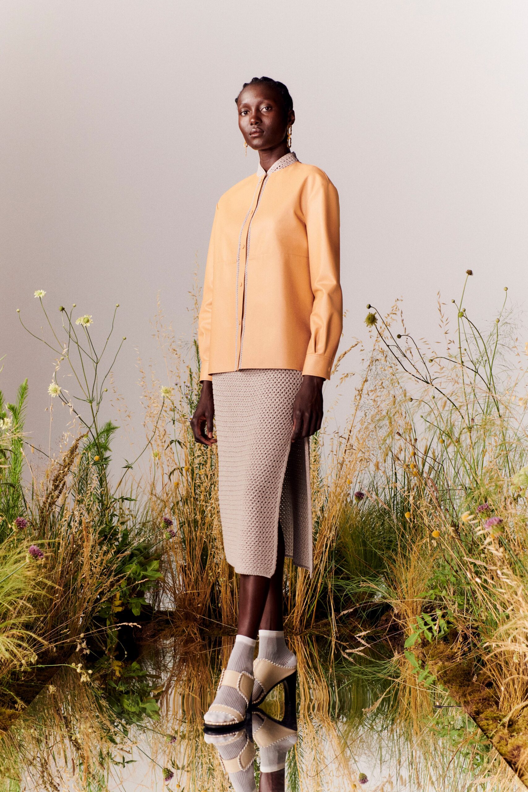 orange fitted blouse with beige pencil skirt