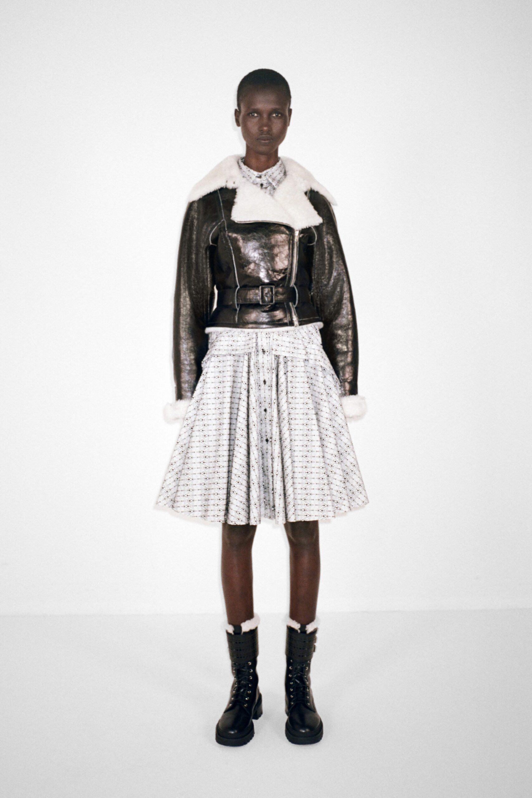 black leather jacket with pleated skirt