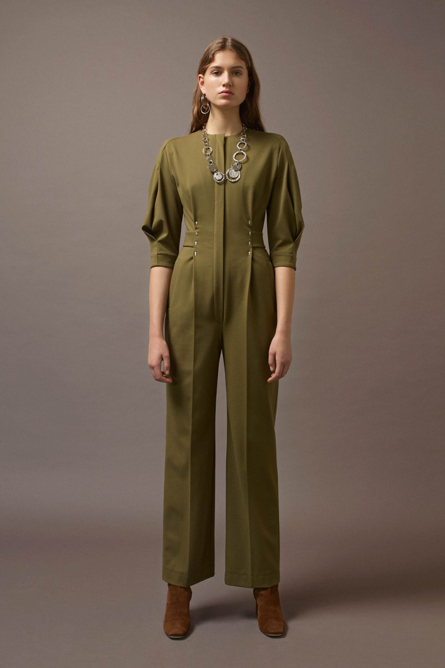 green fitted jumpsuit with brown shoes