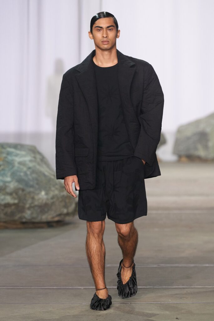 A relaxed black cotton jacket paired with matching black shorts, featuring a collared design.