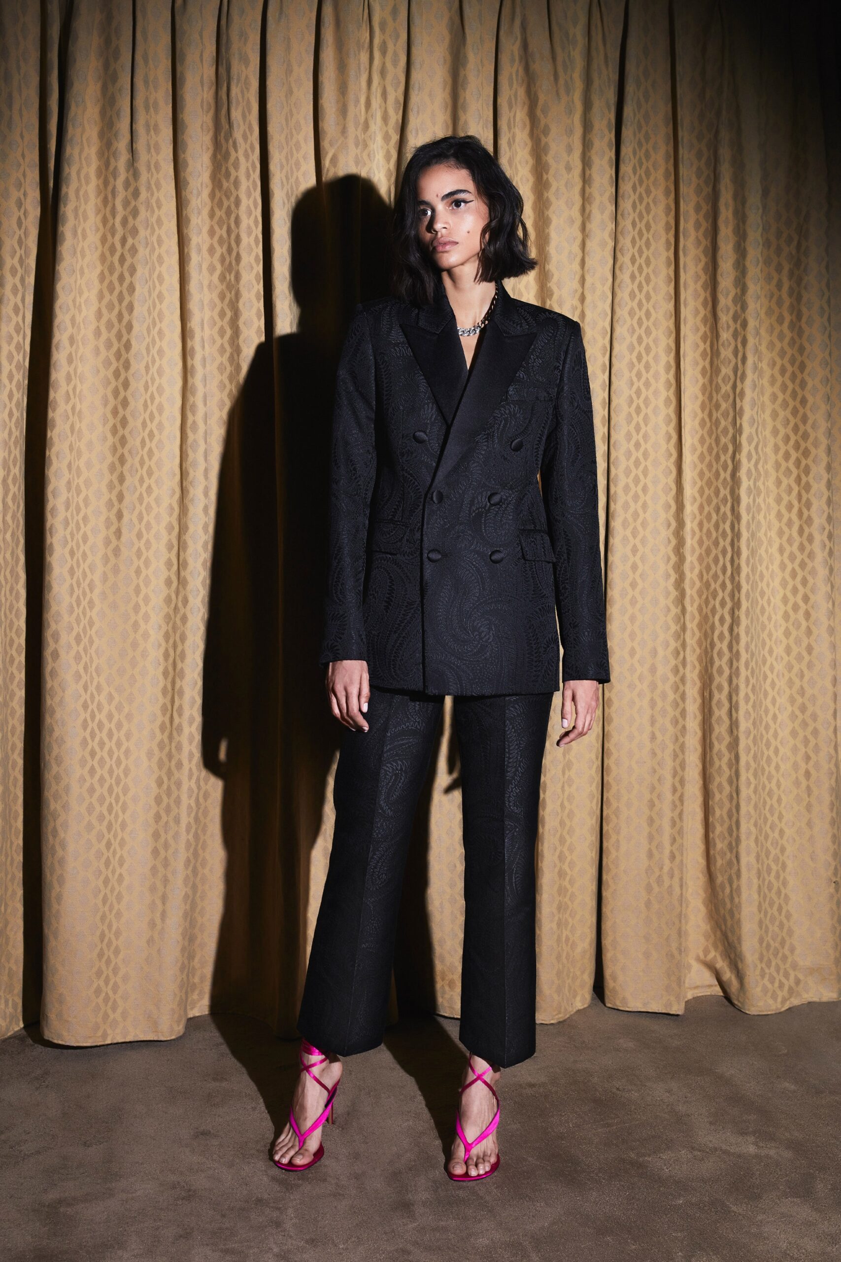 black tailored suit with pink shoes