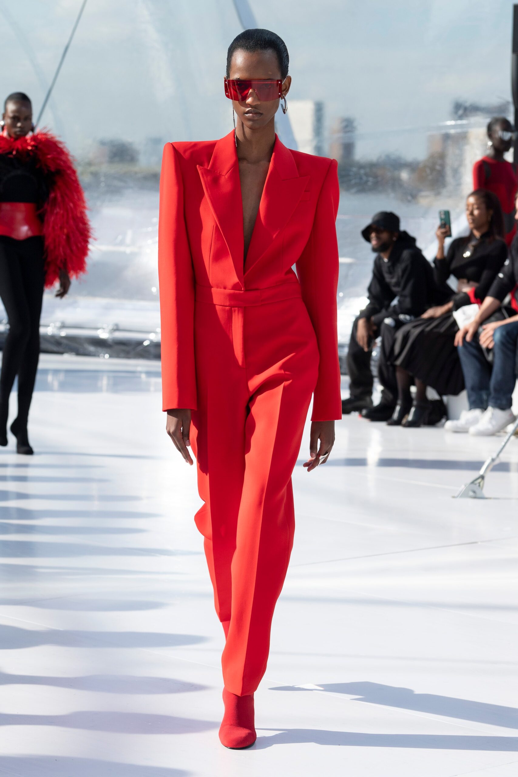 red fitted jumpsuit with oversized sunglasses