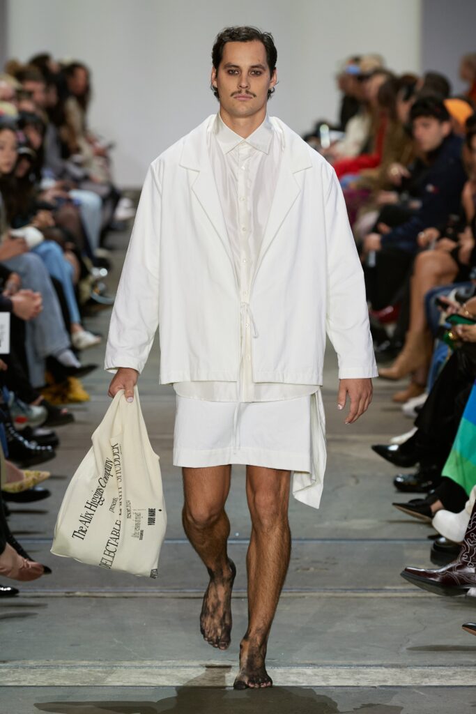 A relaxed white cotton jacket with long sleeves and collared design, paired with matching shorts.