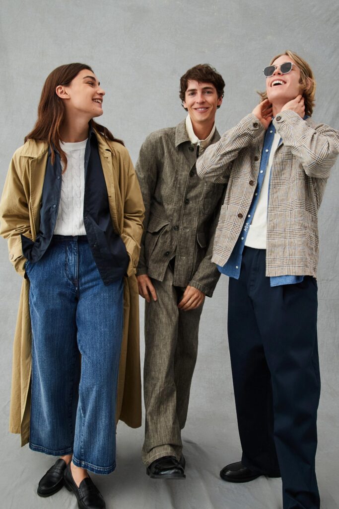 A relaxed beige coat paired with wide-leg blue denim pants, featuring a long-sleeve collared design.