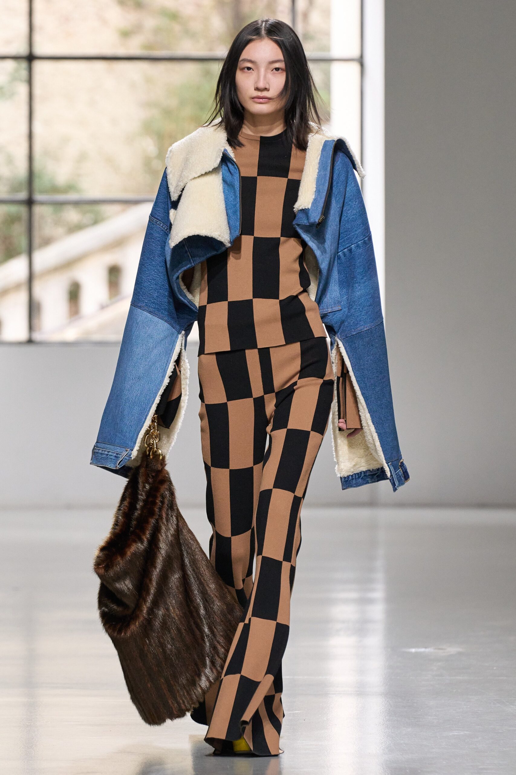 A fitted checked denim jacket paired with flared pants in contrasting colors.