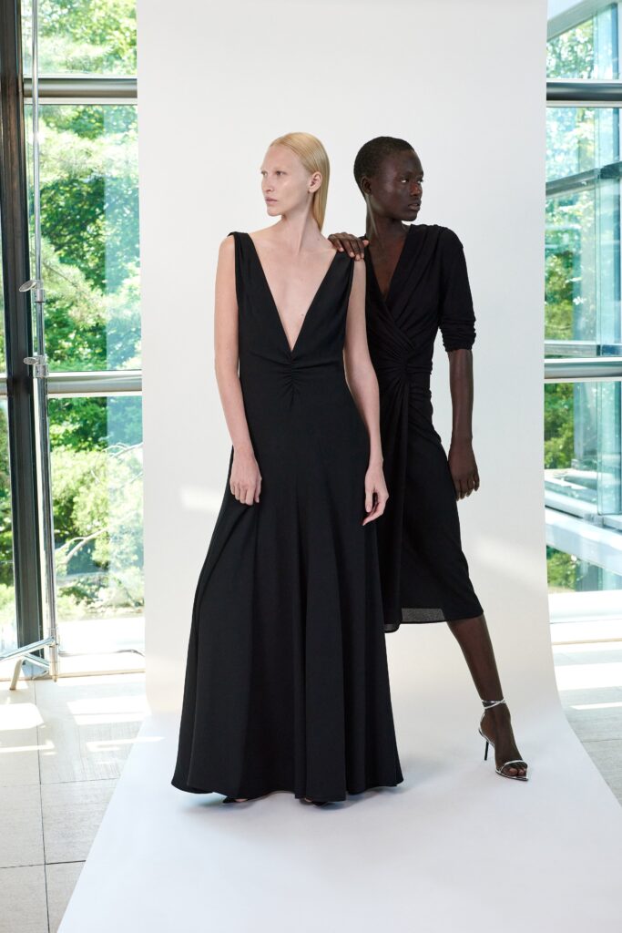 A fitted black silk dress with a sleeveless design and V-neckline in an A-line silhouette.