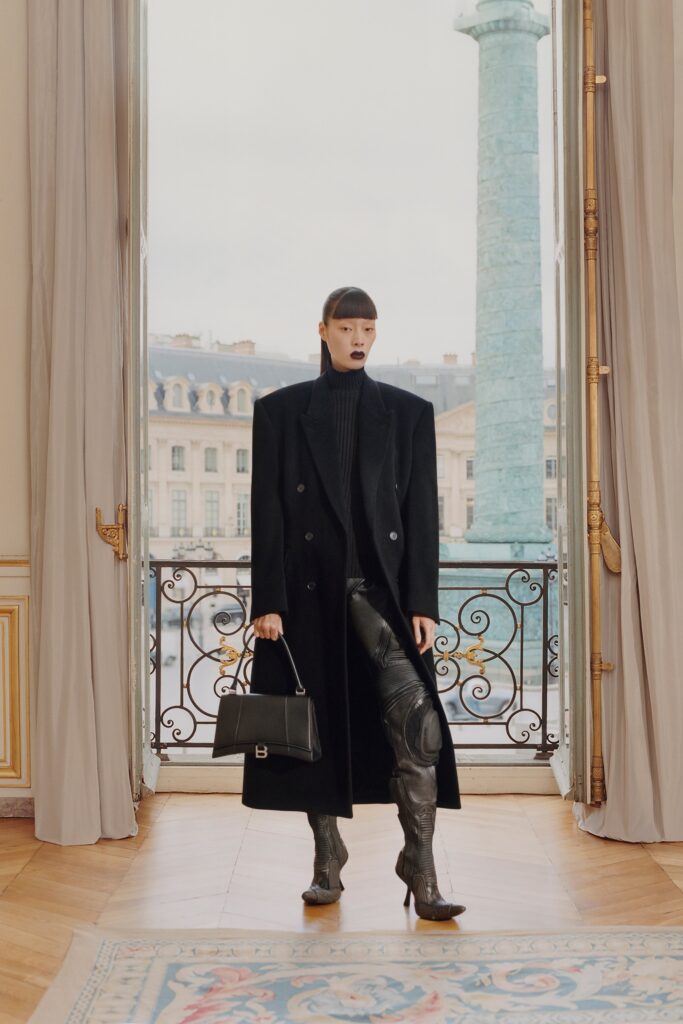 A fitted black leather coat paired with straight-leg pants, featuring a collared design.
