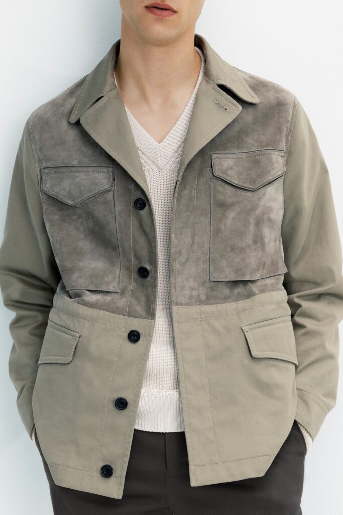 A relaxed gray and beige jacket layered over a v-neck sweater.