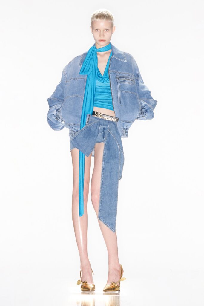 A fitted blue denim jacket paired with a matching top featuring an asymmetric design.
