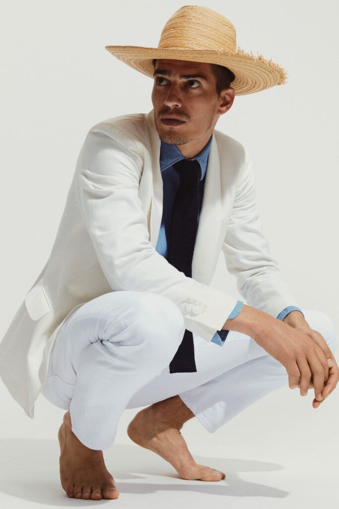 A tailored white blazer paired with blue pants, featuring a collared shirt underneath.