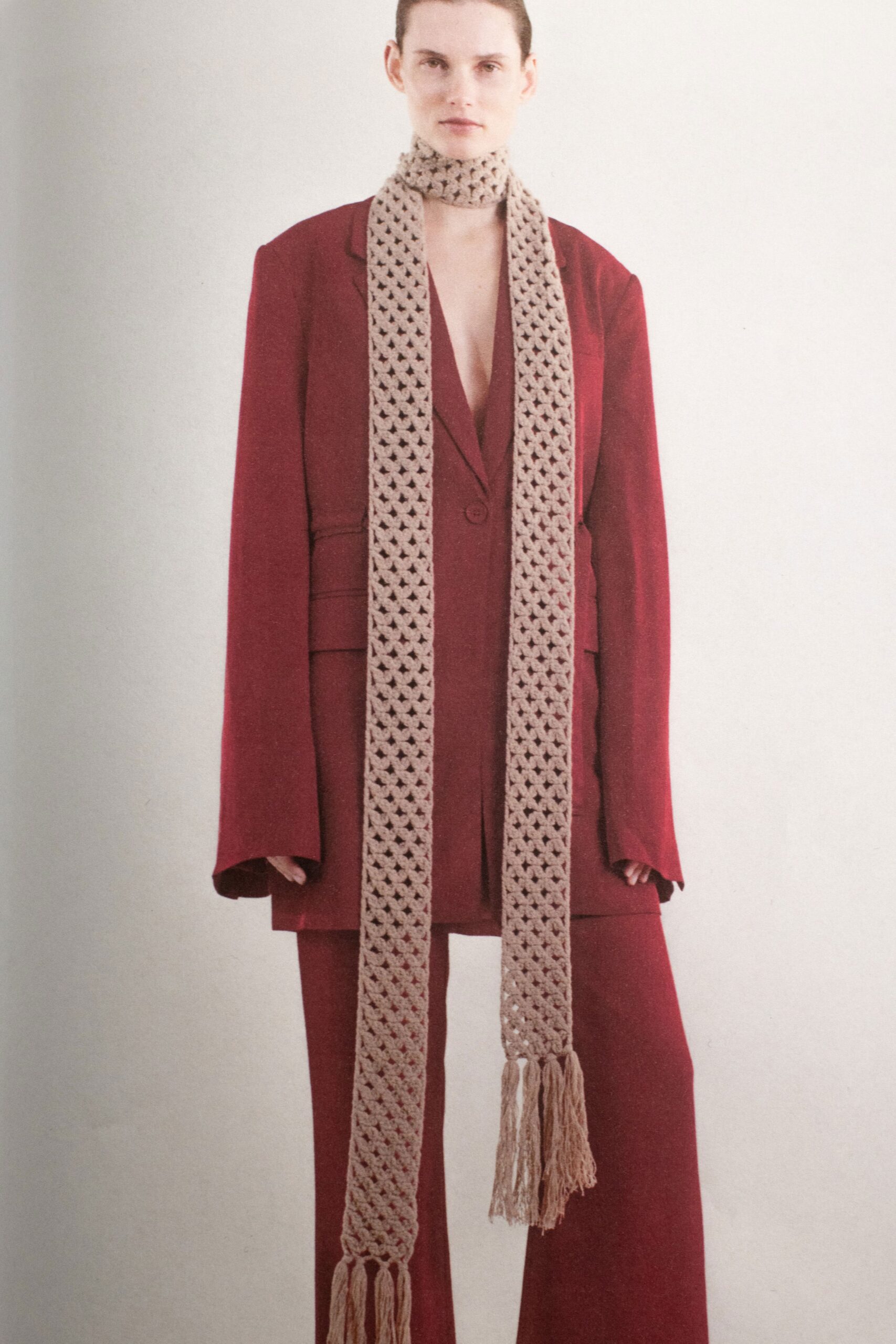 An oversized red wool suit featuring a V-neckline and straight-leg trousers.