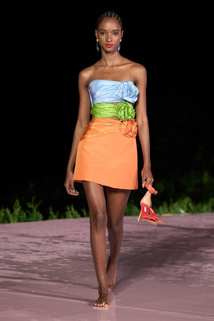 A fitted strapless dress featuring ruffled details in blue, orange, and green colors.
