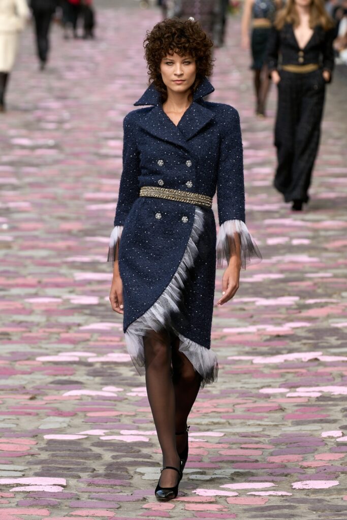 A fitted navy tweed dress with long sleeves, a collared neckline, and an asymmetric silhouette.