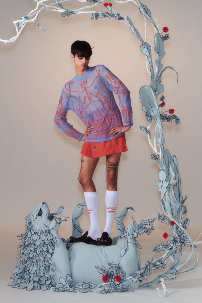 A fitted pink printed long-sleeve top paired with a matching skirt, featuring an asymmetric design.