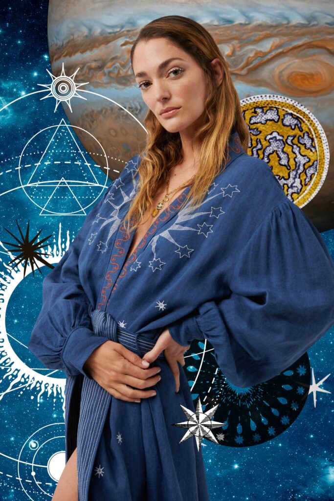 A relaxed blue cotton long-sleeve dress featuring intricate embroidery and a V-neckline.