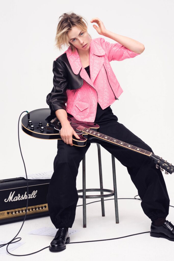 A relaxed pink and black asymmetric jacket paired with relaxed black pants.