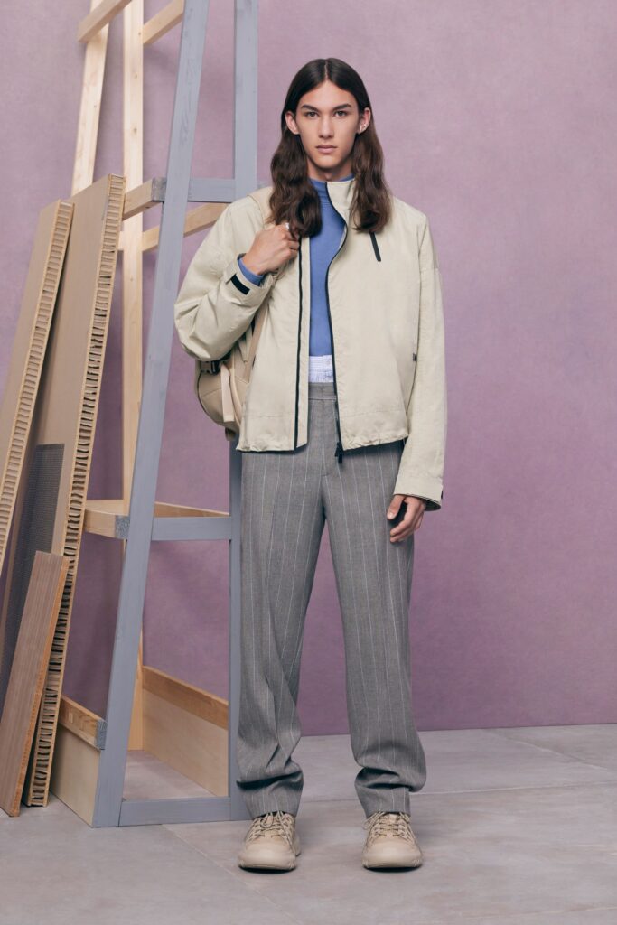 An oversized beige jacket paired with gray striped pants for a modern, casual look.