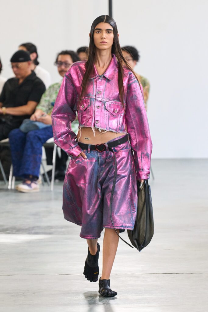 A relaxed pink denim jacket with long sleeves and an asymmetric skirt.