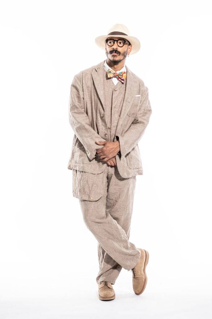 A relaxed beige linen suit with long sleeves and a collared shirt, featuring buttoned details.