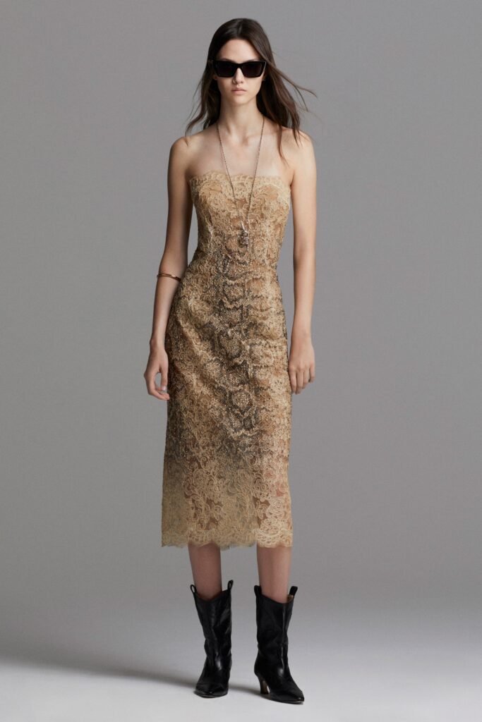 A fitted beige lace strapless dress featuring a stylish slit.