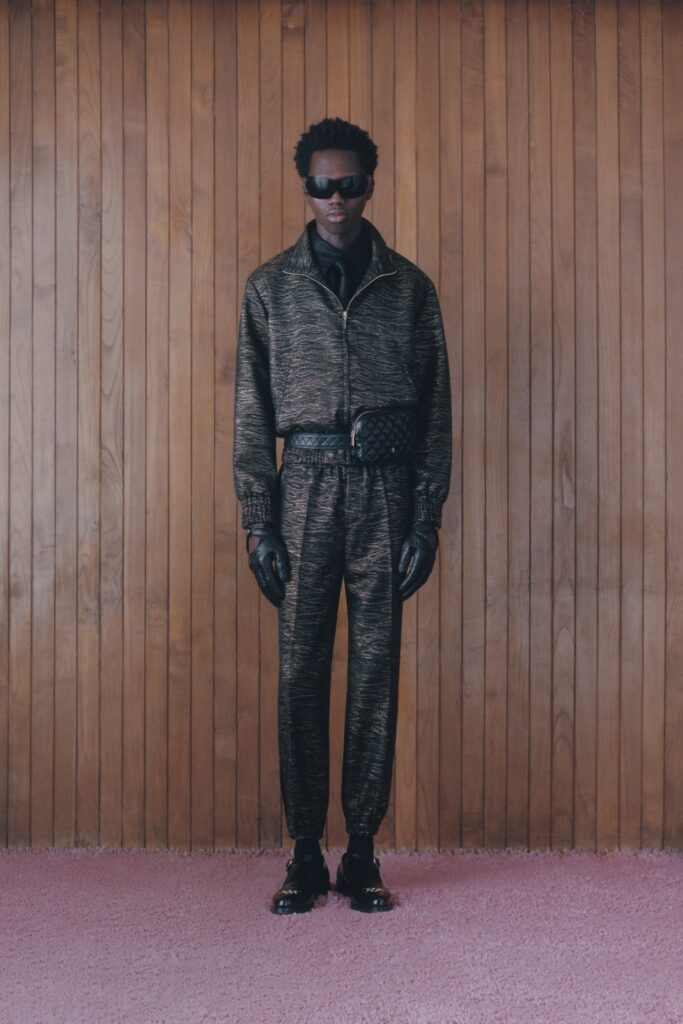 A relaxed black and gold printed jacket with long sleeves and matching pants.