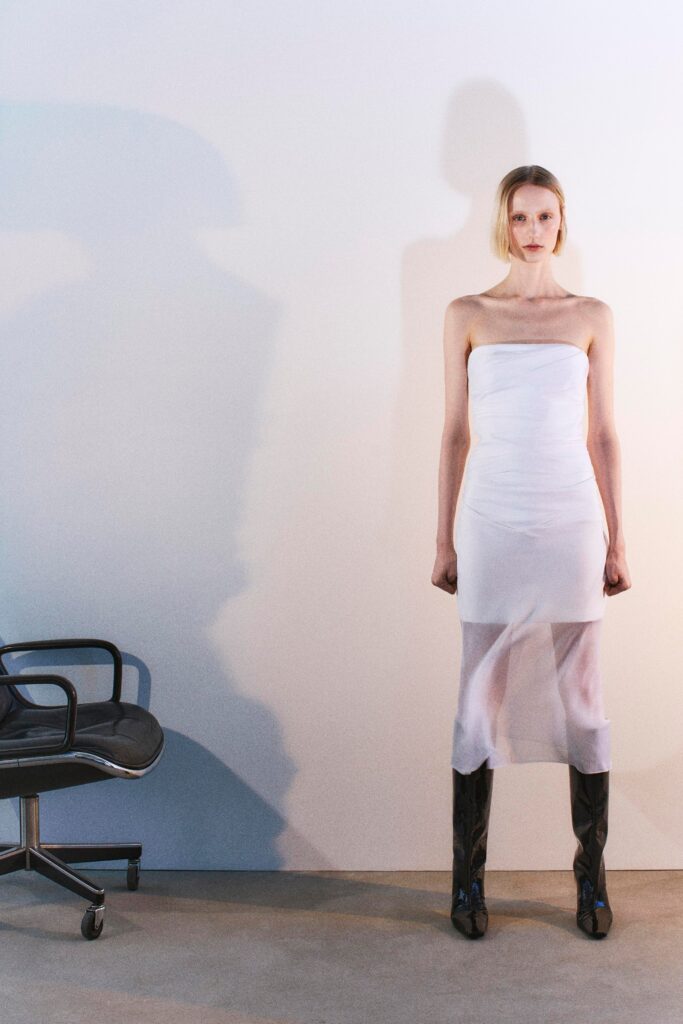 A fitted white silk strapless dress with a sheer design.