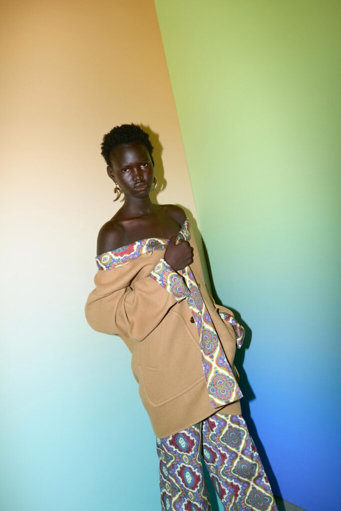 A relaxed beige jacket with a printed design paired with multicolor pants.