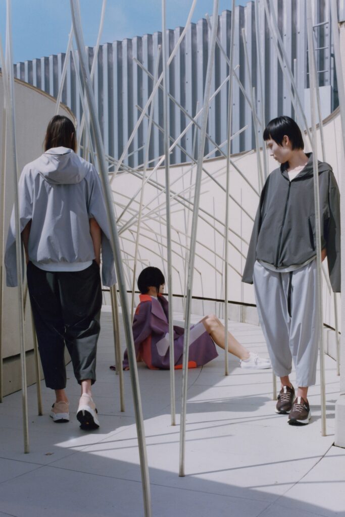 A relaxed gray jacket with long sleeves and asymmetric design paired with matching pants.