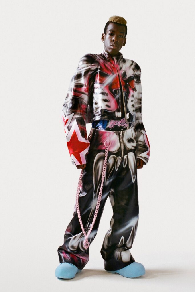 An oversized black and red printed jacket paired with matching pants, creating a bold streetwear look.