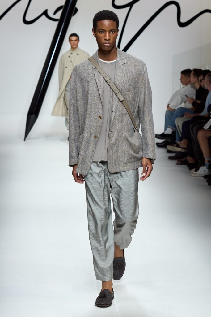A relaxed gray blazer with long sleeves and collared design paired with straight-leg pants.