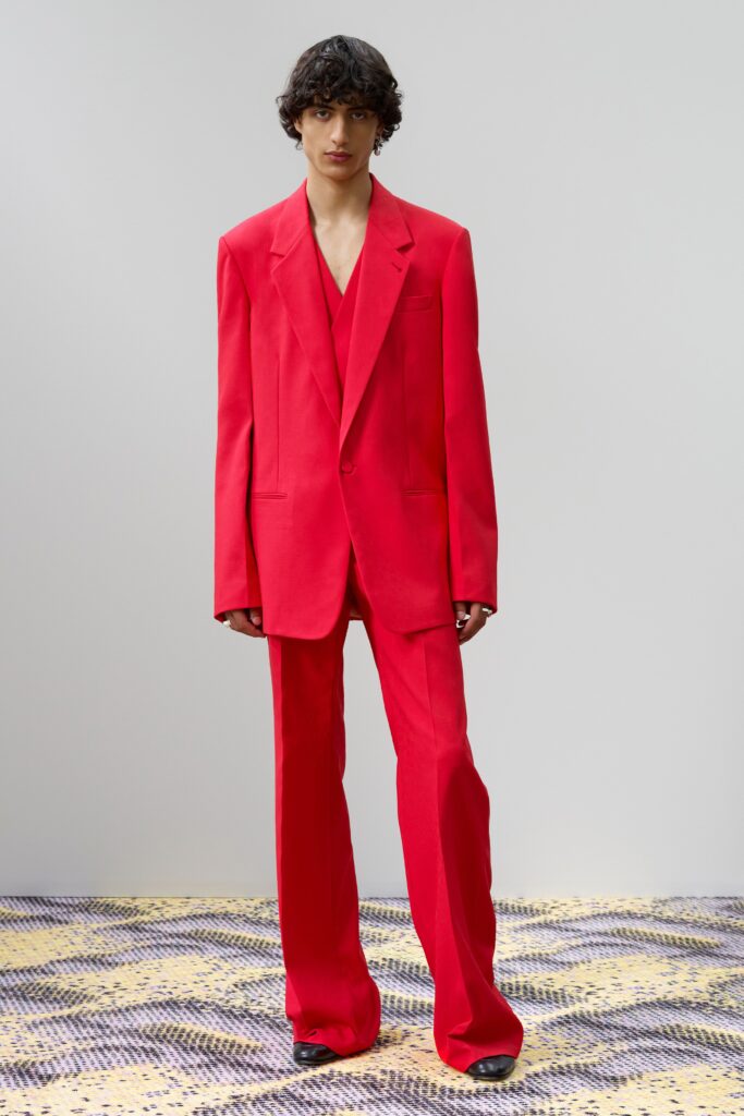 A fitted red suit with a V-neckline and straight-leg trousers.