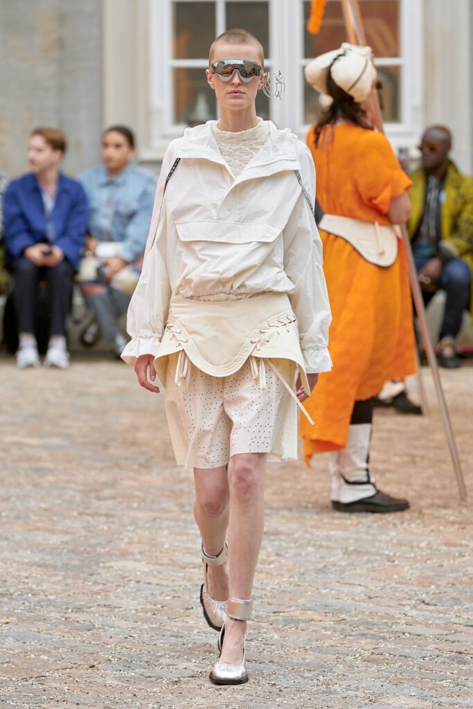 A relaxed white cotton long-sleeve top with high-waisted shorts featuring a layered design.