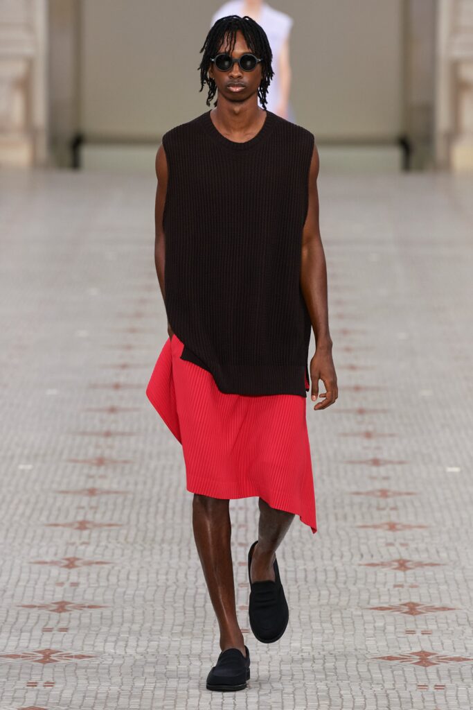 brown knit sleeveless top and red pleated skirt