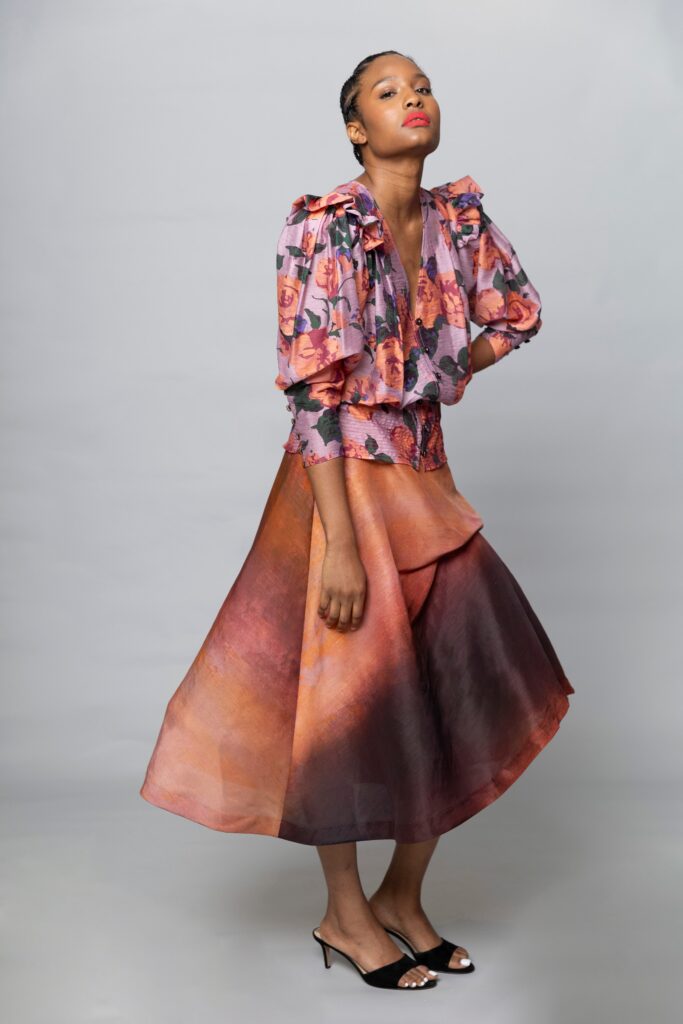 A relaxed pink and orange silk dress with long sleeves and a V-neckline featuring a flared silhouette.
