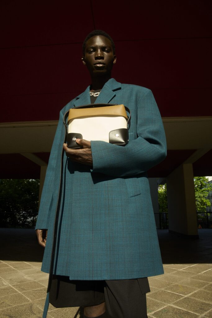 An oversized blue coat paired with black shorts, creating a stylish and contemporary look.