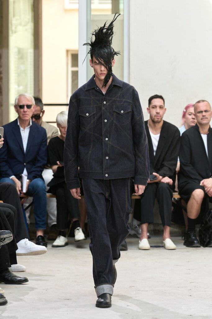 A relaxed fit blue denim jacket with long sleeves and collared design paired with straight-leg pants.