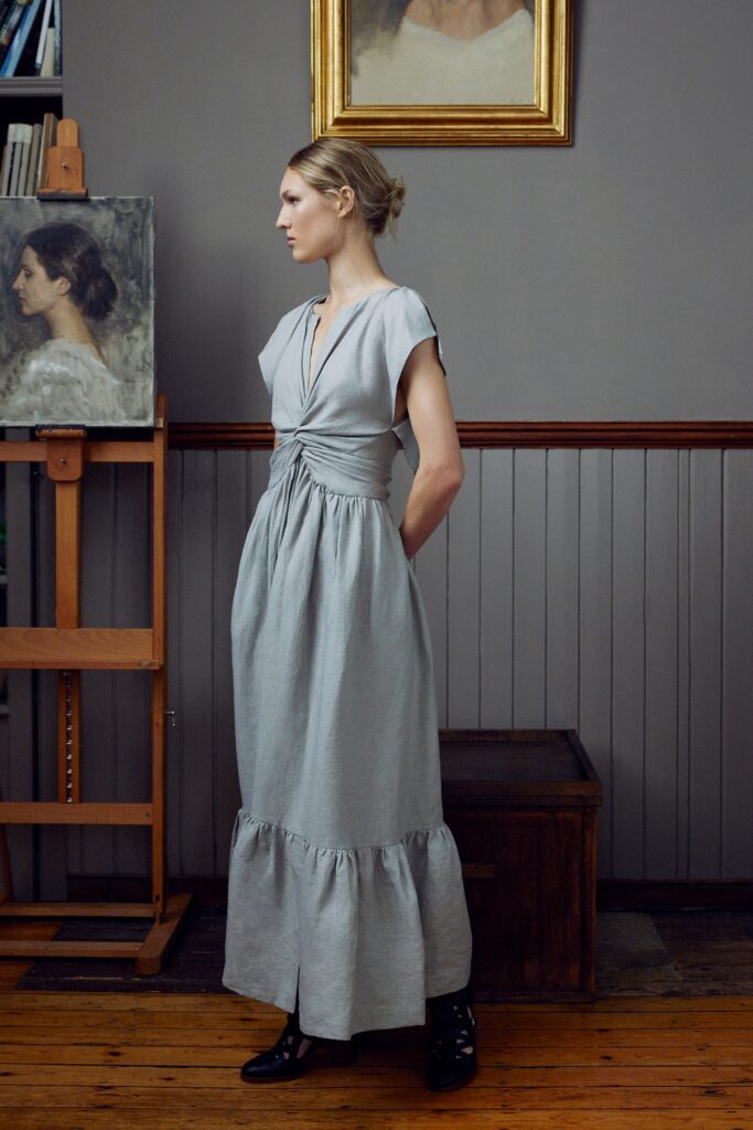 A relaxed gray cotton dress with short sleeves, a V-neckline, and a tiered hem.