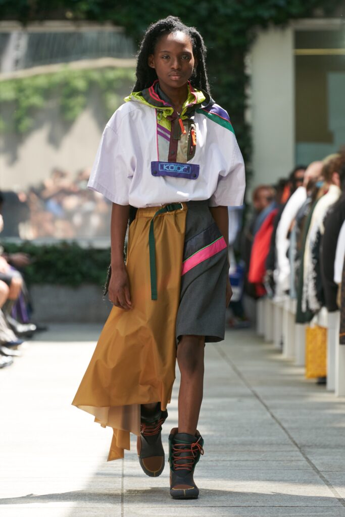 A relaxed brown and gray dress with short sleeves, high neckline, and asymmetric layered design.