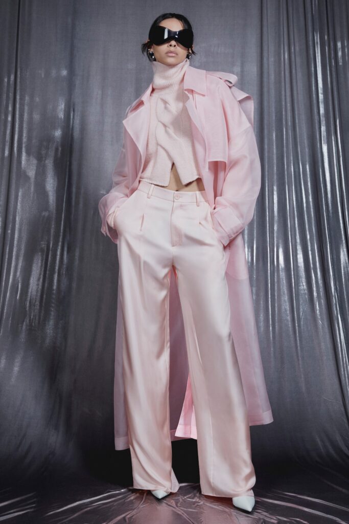 A relaxed pink silk coat layered over a high-neck top with long sleeves.