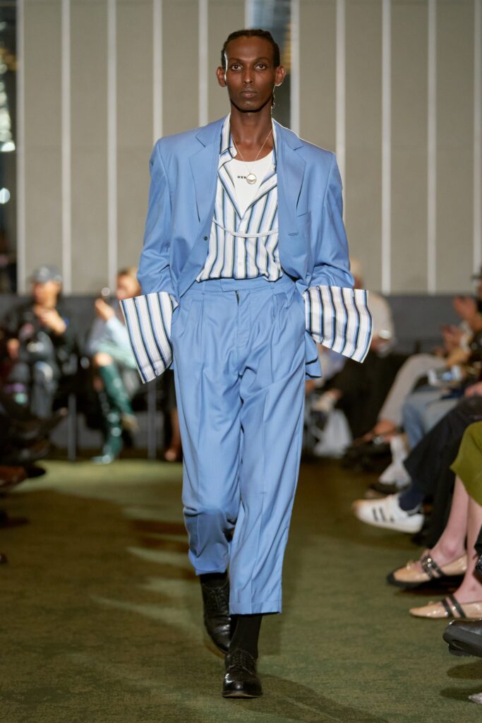 A relaxed blue cotton suit with long sleeves and a collared shirt featuring stripes.